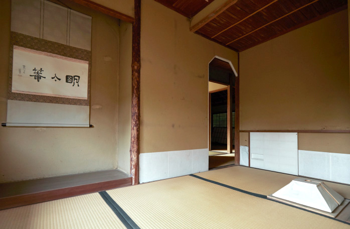 12 明々庵では手前畳に炉が切られている。茶道口の「はかまごし」は、袴姿を背中側から見た形を意匠化。