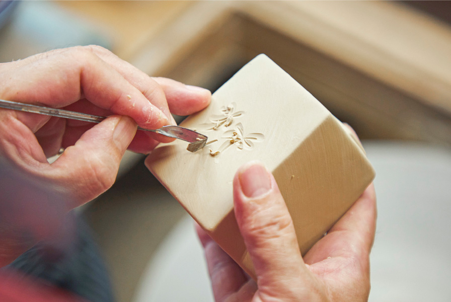 16　完全に乾ききる前に、金属の棒を巧みに操り、花の姿を彫り上げる。